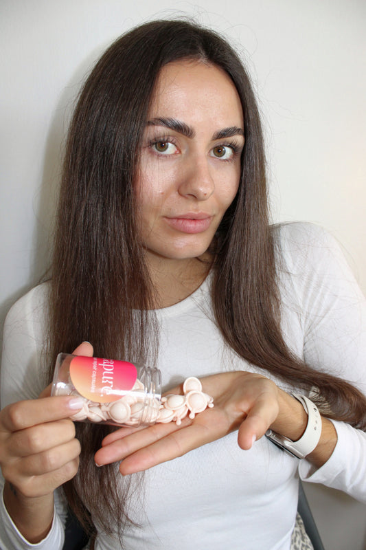 JEUNE-FEMME-BRUNE-FACE-CAMERA-QUI-TIENT-DES-CAPSULES-CAPURE